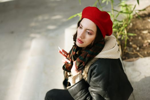A young, stylish woman with a vibrant red beret and a chic leather jacket, radiating trendy urban fashion vibes