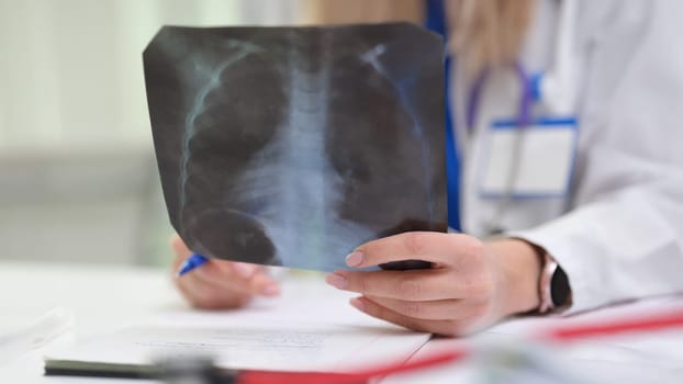 A dedicated healthcare worker carefully examines a chest Xray, ensuring an accurate and precise diagnosis