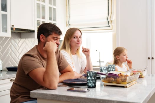Family enjoying meal together in a modern kitchen close up