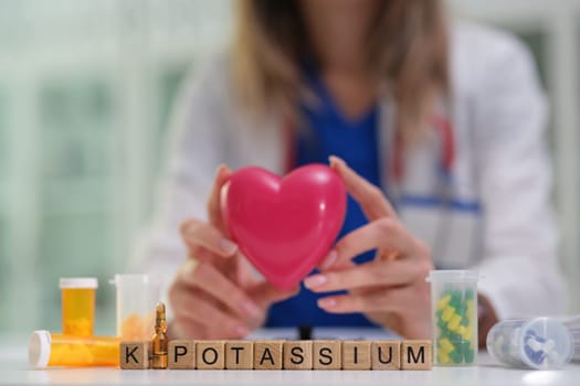 A dedicated medical professional skillfully holds a detailed heart model, showcasing potassiums vital health role