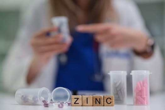 A healthcare professional is sorting different zinc supplements in a pharmacy filled with colorful containers