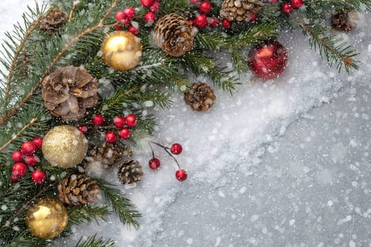 Festive Christmas and New Year Decoration with Snow.Space for text.A beautifully arranged Christmas and New Year decoration featuring snow-covered pine branches adorned with golden and red baubles, pinecones, and vibrant red berries. The scene captures the essence of the holiday season with its festive ornaments and a gentle snowfall, creating a warm and inviting winter atmosphere.