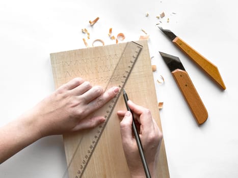 Hands crafting wood with precision tools and geometric patterns design.