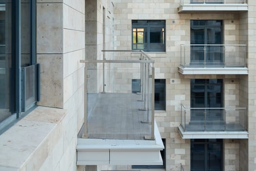 This is a beautifully sleek balcony design featuring an elegant glass railing within a modern apartment building