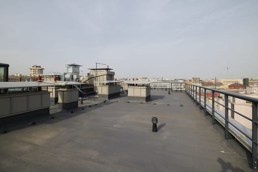 A captivating panoramic view of an urban rooftop featuring industrial structures and essential equipment