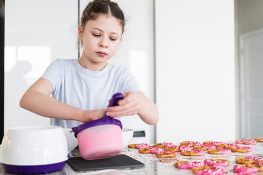 With focused attention, this budding culinary artist dips pretzels into a pot of melted chocolate, creating sweet delights in the warmth of a well-lit home kitchen.