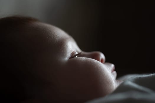 Macro close-up shot of a baby's eyes with eyelashes and chubby cheeks. Childhood and baby concept. High quality photo
