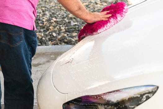 Denver, Colorado, USA-September 1, 2023-Efficiently cleaning an electric car in the comfort of a suburban driveway, combining eco-consciousness with practicality.
