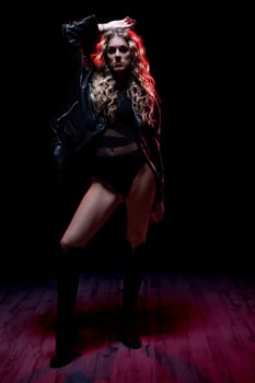 A striking fashion model poses confidently in dramatic lighting, showcasing modern style and attitude.