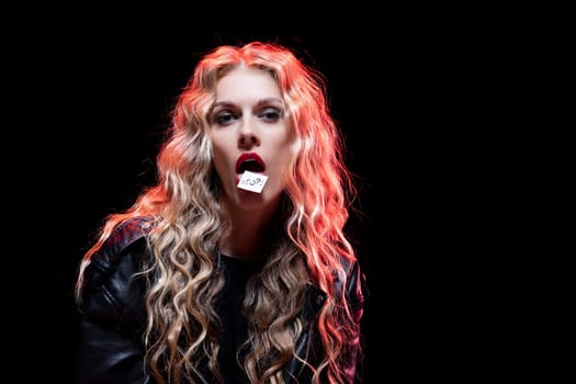 A captivating portrait shows a stunning model with vibrant curly hair and bold makeup against a dark backdrop