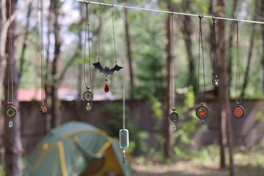 A cozy campsite scene featuring an inviting array of colorful hanging ornaments beautifully arranged in the woods