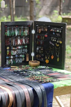 A vibrant and colorful array of unique handmade jewelry and stylish belts beautifully displayed at an outdoor market