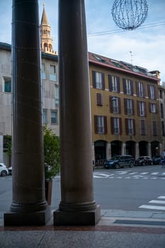 Cremona, Italy - November 27th 2024 Columns with christmas lights framing a glimpse of torrazzo bell tower and buildings in cremona, italy