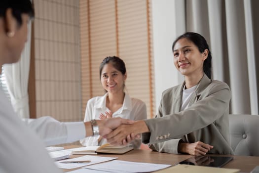 Businessmen shaking hands in a modern office, symbolizing successful partnership and collaboration.