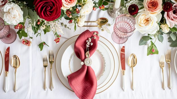 Festive table setting with candles and arrangement of beautiful red flowers. Holiday concept. High quality photo