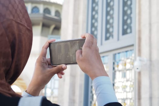 A person holds a smartphone high above to capture and appreciate the beauty of nature outdoors