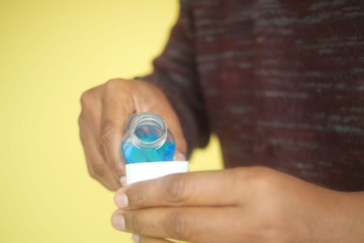 mouthwash liquid flowing into a cap , close up