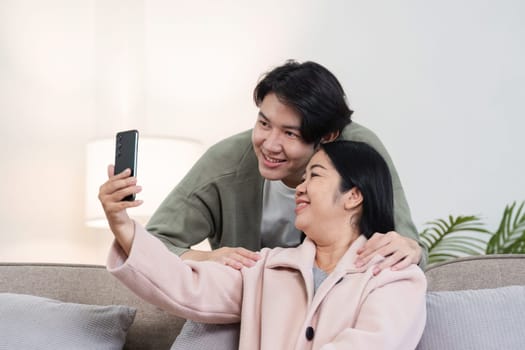 A mother and son share a joyful moment together on holiday, engaging in activities and capturing memories with a smartphone.