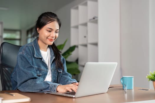 A young woman studying online at home, using a laptop, and staying focused and engaged in her remote education.