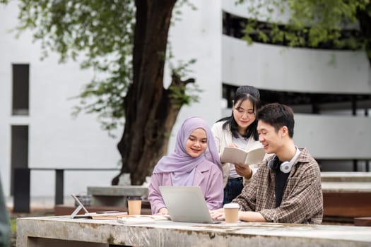 A diverse group of students gathers outdoors, collaborating and studying with laptops and books in preparation for an upcoming exam.