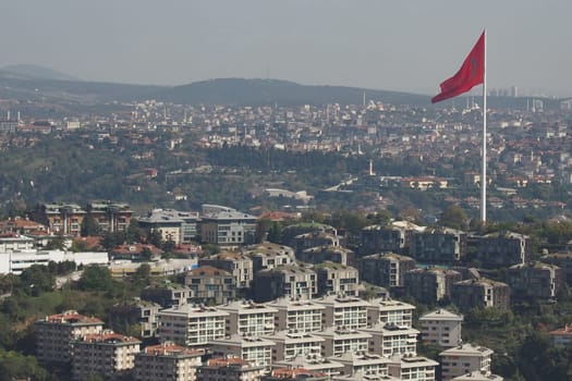 A beautiful scenic urban view that prominently features modern architecture and the Turkish flag