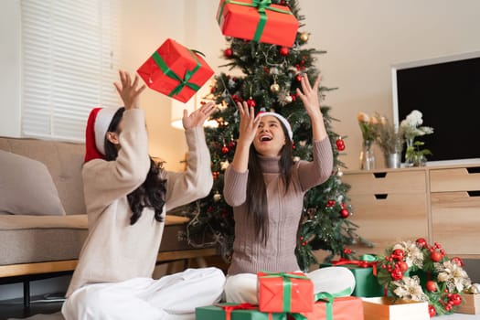 A young couple decorates their room for Christmas, creating a festive and joyful atmosphere to celebrate the holiday season together.