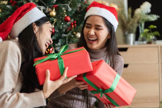 Joyful lesbian couple celebrating Christmas with gifts, laughter, and festive decorations, capturing the spirit of the holiday season.