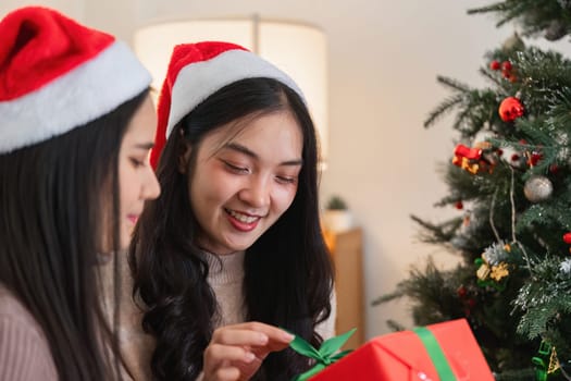 Two young women delight in exchanging surprise gifts on Christmas, capturing the joy and warmth of the holiday season.