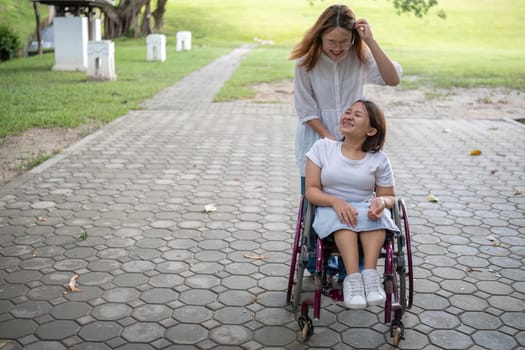 A joyful moment as a young woman in a wheelchair and her best friend enjoy a walk in the park together.