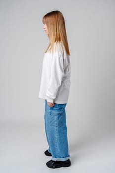 Adult female standing in casual attire with long hair, side profile captured in a minimalist studio setting close up