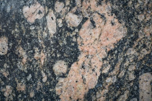 Close-up view of polished granite surface revealing intricate patterns and mineral composition, ideal for backgrounds or design projects.