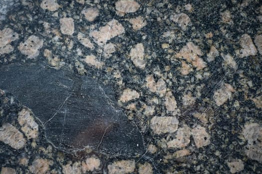 Polished granite stone showing pink feldspar crystals embedded in dark matrix.
