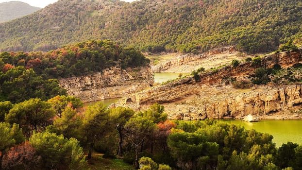 A stunningly beautiful view of majestic mountains, lush trees, and a serene, calm lake in the peaceful countryside
