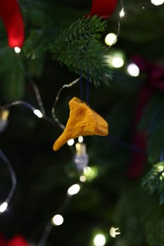 A vibrant yellow ornament perfectly hanging amidst colorful festive lights beautifully adorning a Christmas tree