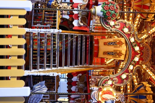 A beautifully decorated carousel staircase featuring intricate designs and warm inviting lighting throughout