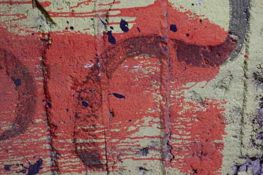 A closeup view of vibrant red and yellow graffiti art, illustrating the diverse textures of urban street art