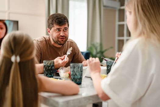 Family enjoying meal together in a modern kitchen close up