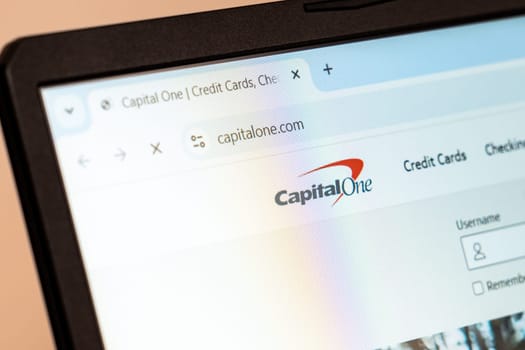 New York, USA - December 21, 2024: Capital One website homepage displayed on laptop screen with logo. Financial services company offering banking, credit cards, and loans