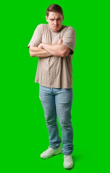 Man with a neutral expression poses against a bright green backdrop in studio