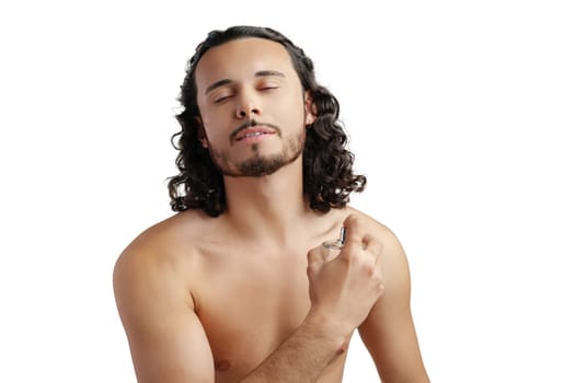 A young man with curly hair applying fragrance after a shower while smiling at the camera close up