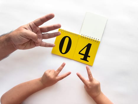 Counting hands with calendar on a white background celebrating number four.