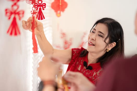An elderly couple decorates their home for Chinese New Year embracing traditions and festivities together.