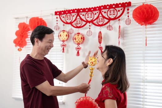 A joyful elderly couple enjoys the festivities of Chinese New Year surrounded by vibrant decorations and happy moments.