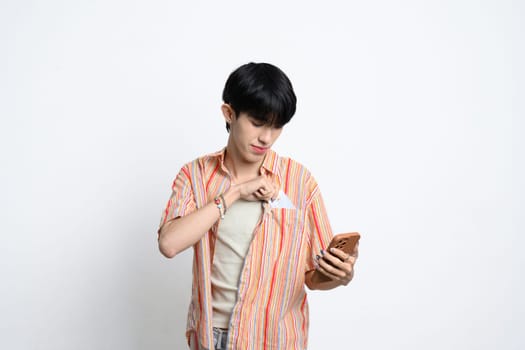 Smiling man holding smartphone and taking out a credit card from his pocket.