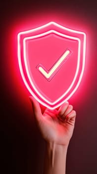A close-up of a hand holding a neon pink shield with a checkmark, representing security, trust, and protection. The vibrant glow highlights the importance of safety and reliability