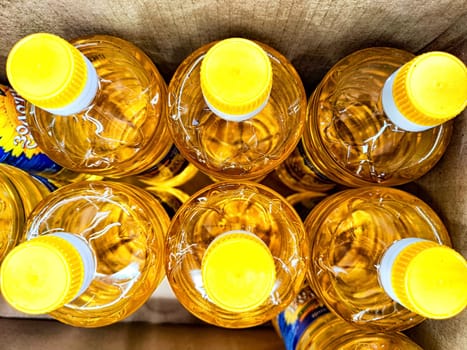 Several bright yellow bottles with caps are organized in a cardboard box, showcasing a vibrant arrangement ideal for beverage storage.