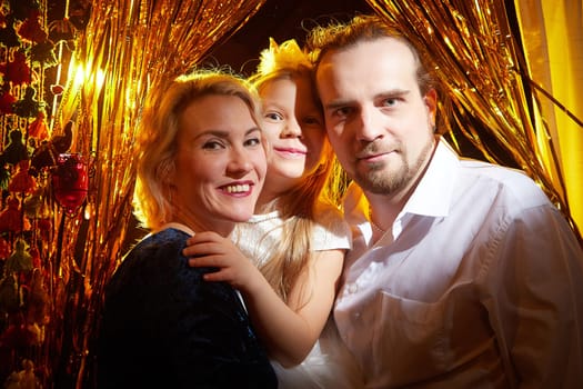 Joyful family embraces the holiday spirit, celebrating Christmas and New Year amidst shimmering decorations and bright lights.