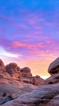 A breathtaking view of rock formations bathed in the warm hues of a sunset. The sky transitions from deep blue to pink and orange, highlighting the rugged beauty of the terrain. Perfect for nature and travel themes