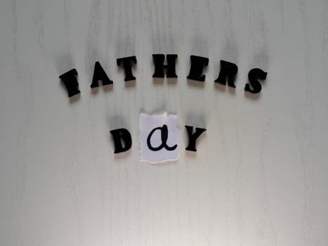 Lettering father in black letters on grey background on father's day close-up