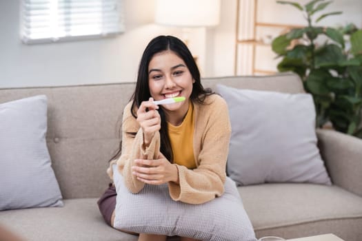 A woman joyfully discovers her pregnancy test result celebrating new beginnings in a comforting home environment.